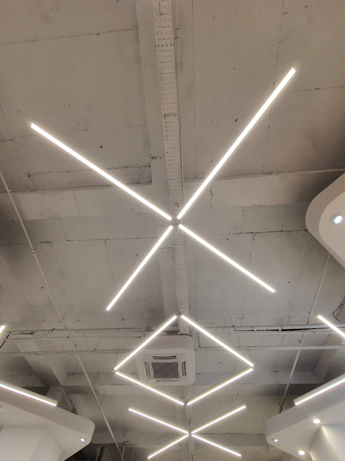 Bright LED lighting fixtures illuminating a commercial office space with sleek ceiling design