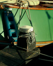 Side view of a vessel’s mooring lines tightly fastened to a heavy-duty marine bollard.