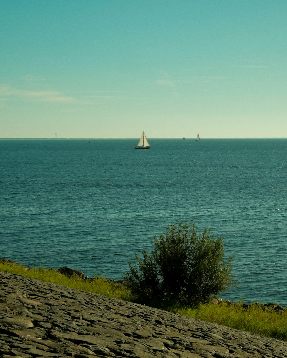 a sailboat is out on the water in the distance