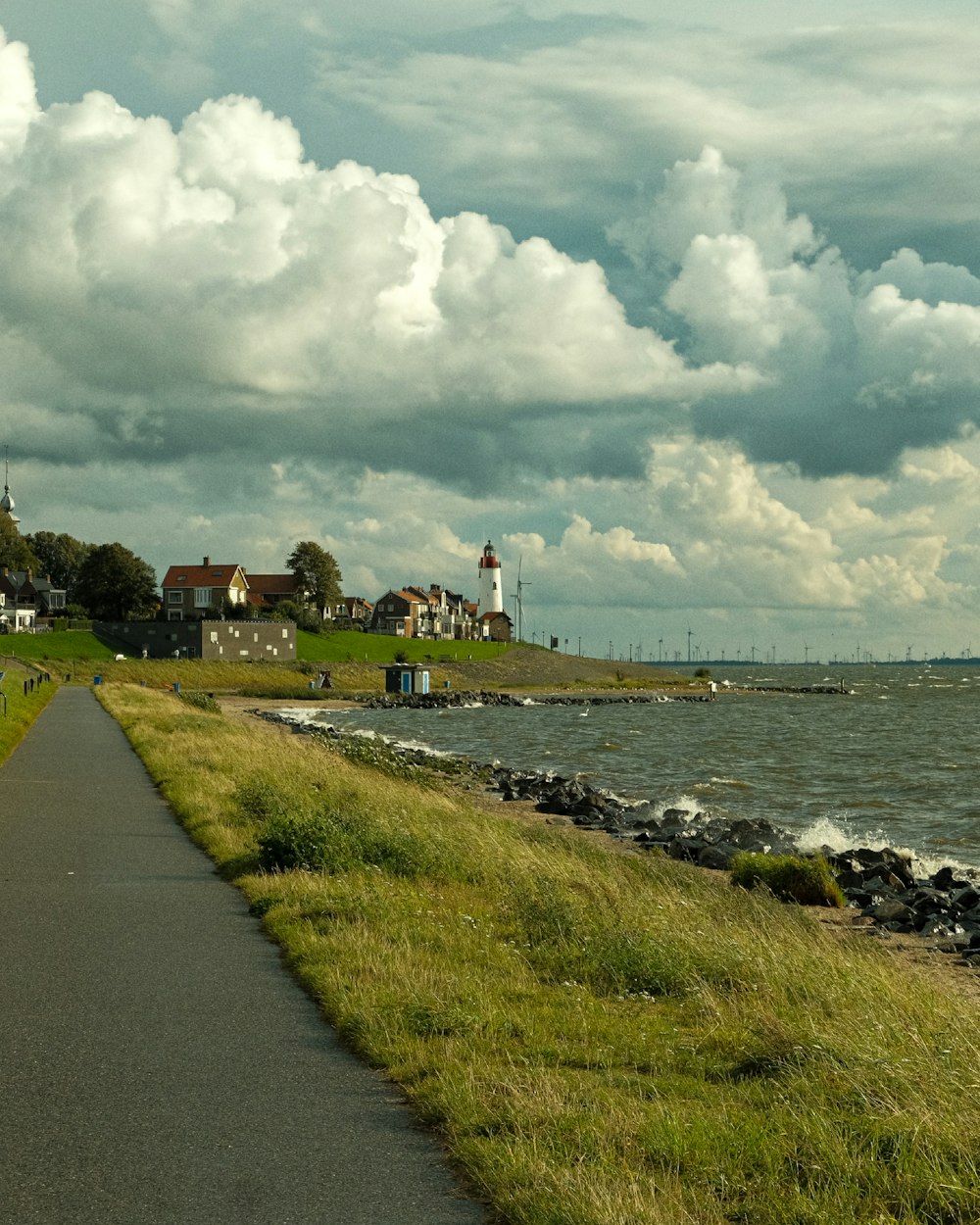 a paved path next to a body of water
