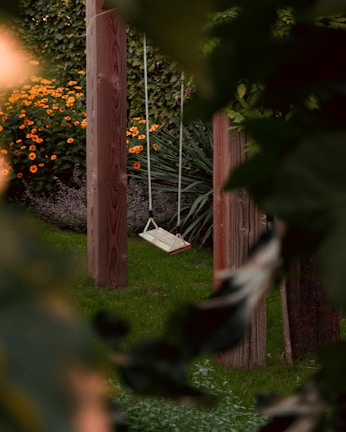 A sunny garden corner with colorful flowers and a wooden swing gently swaying.