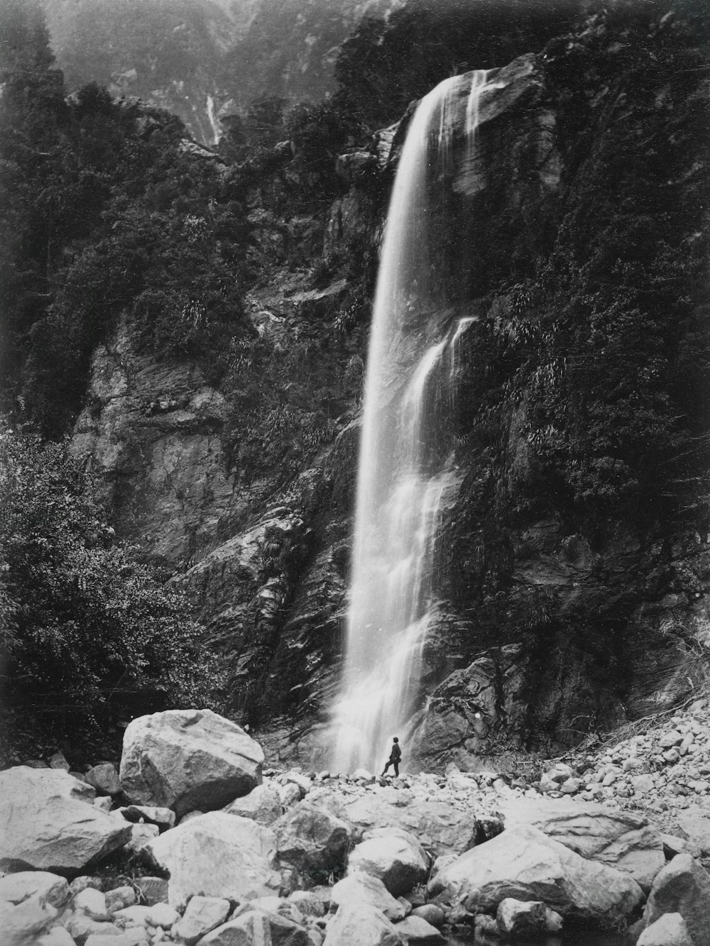 a man standing in front of a waterfall