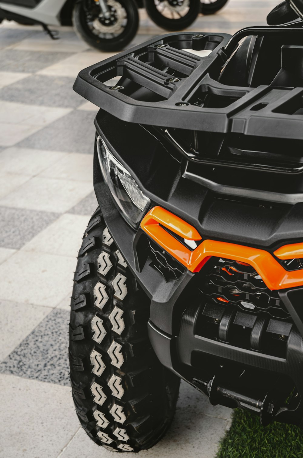 an orange four wheeler parked on a checkered tile floor