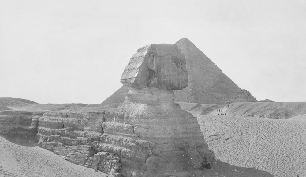 a black and white photo of a pyramid in the desert
