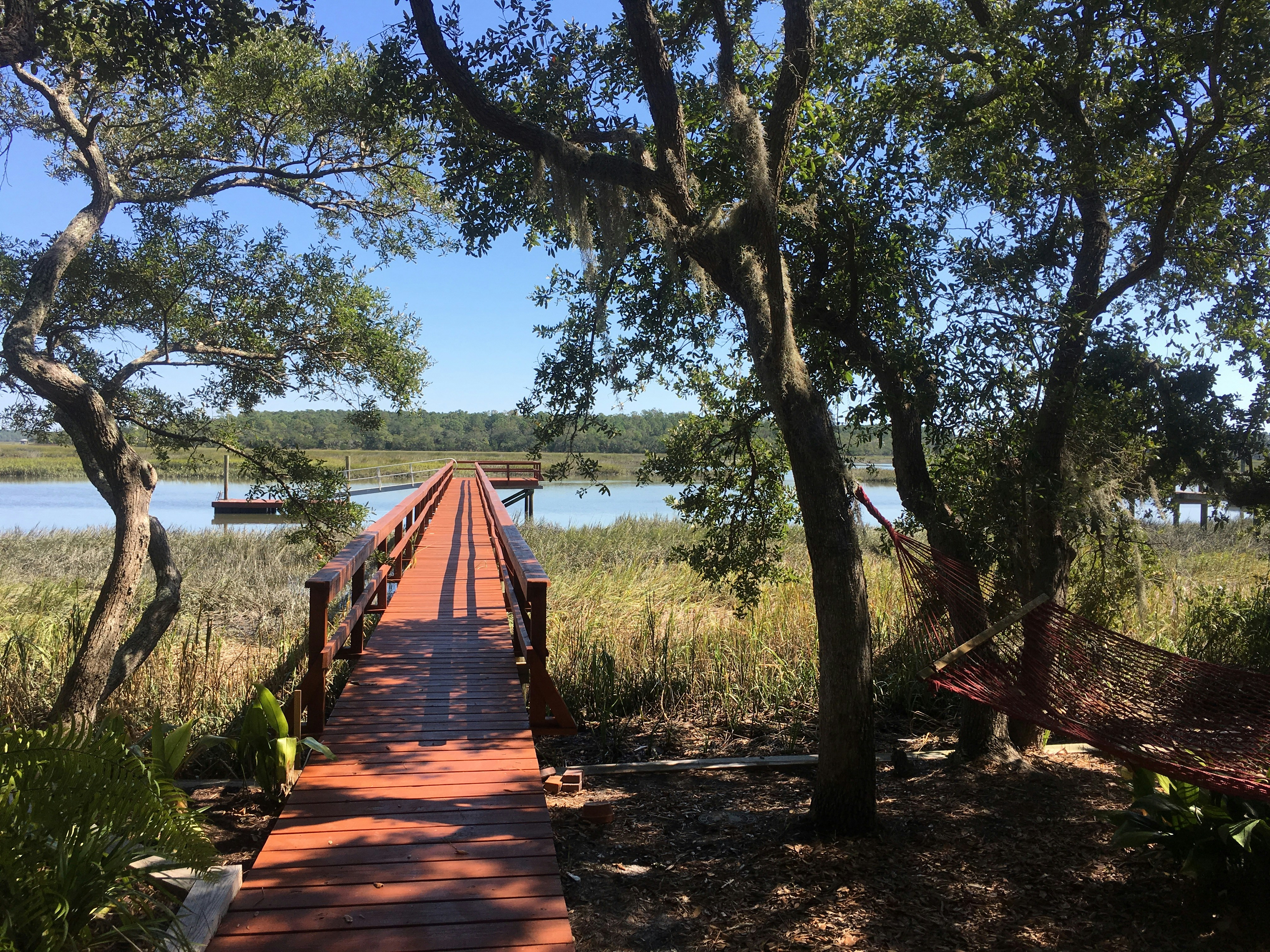 a wooden bridge over a body of water surrounded by trees