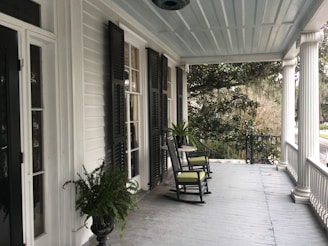 Beautifully crafted front porch with rocking chairs overlooking a quiet neighborhood street.