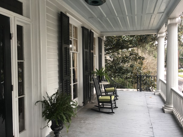 Beautifully crafted front porch with rocking chairs overlooking a quiet neighborhood street.