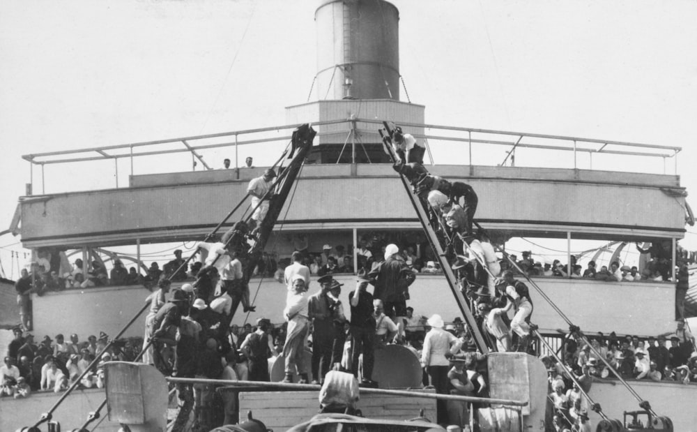 un grande gruppo di persone in piedi sul retro di una barca