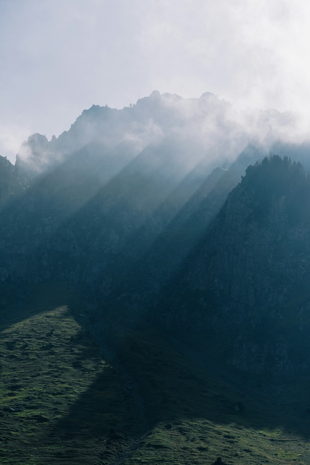 a mountain range with a few clouds in the sky