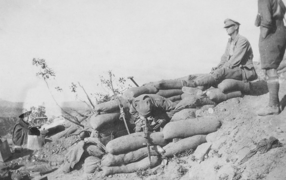 a group of men standing on top of a pile of bags