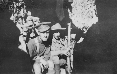 Black and white photo of soldiers in trenches during World War I.