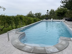 a large swimming pool surrounded by a stone patio