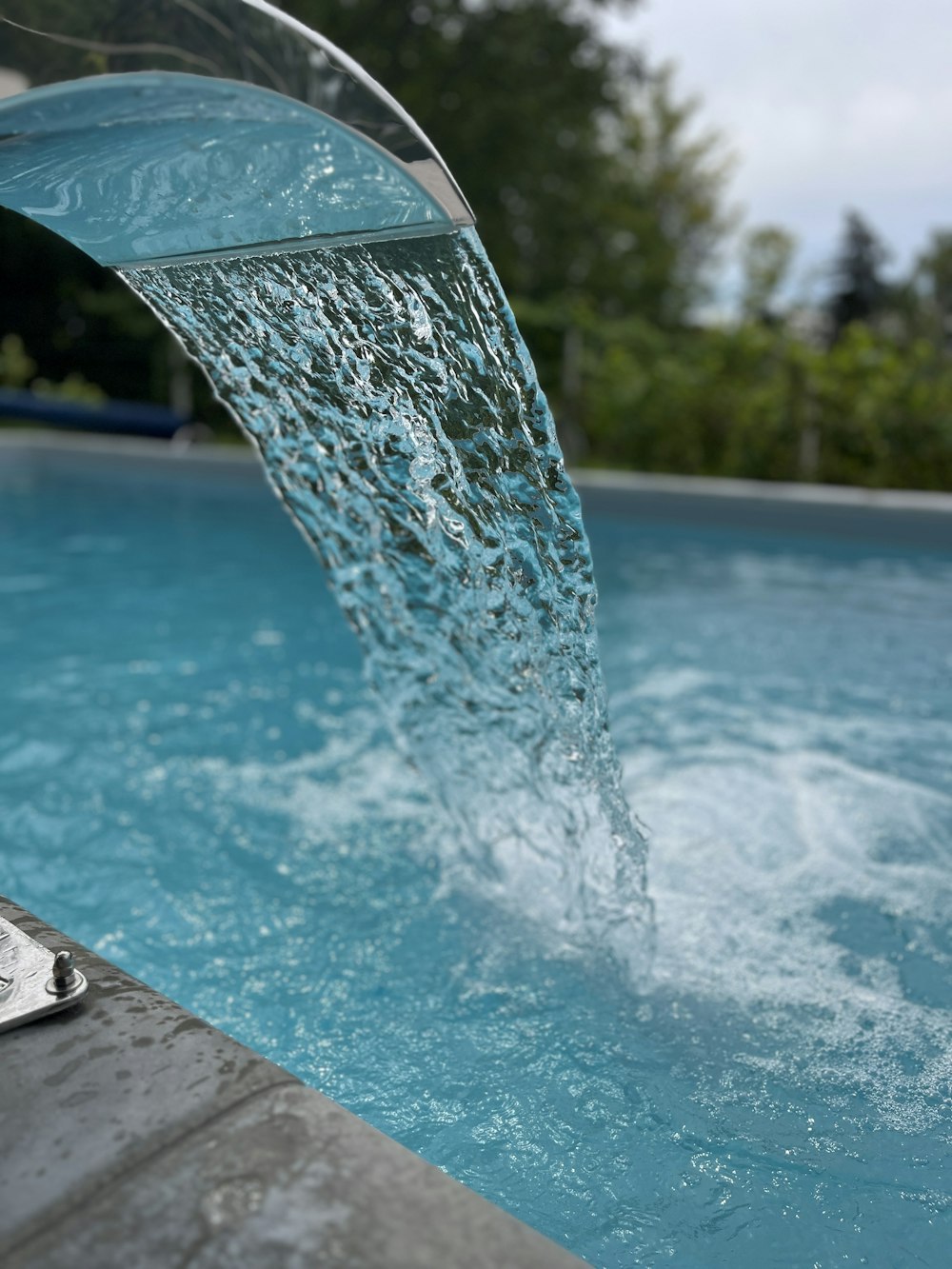 a water spouting from the side of a swimming pool