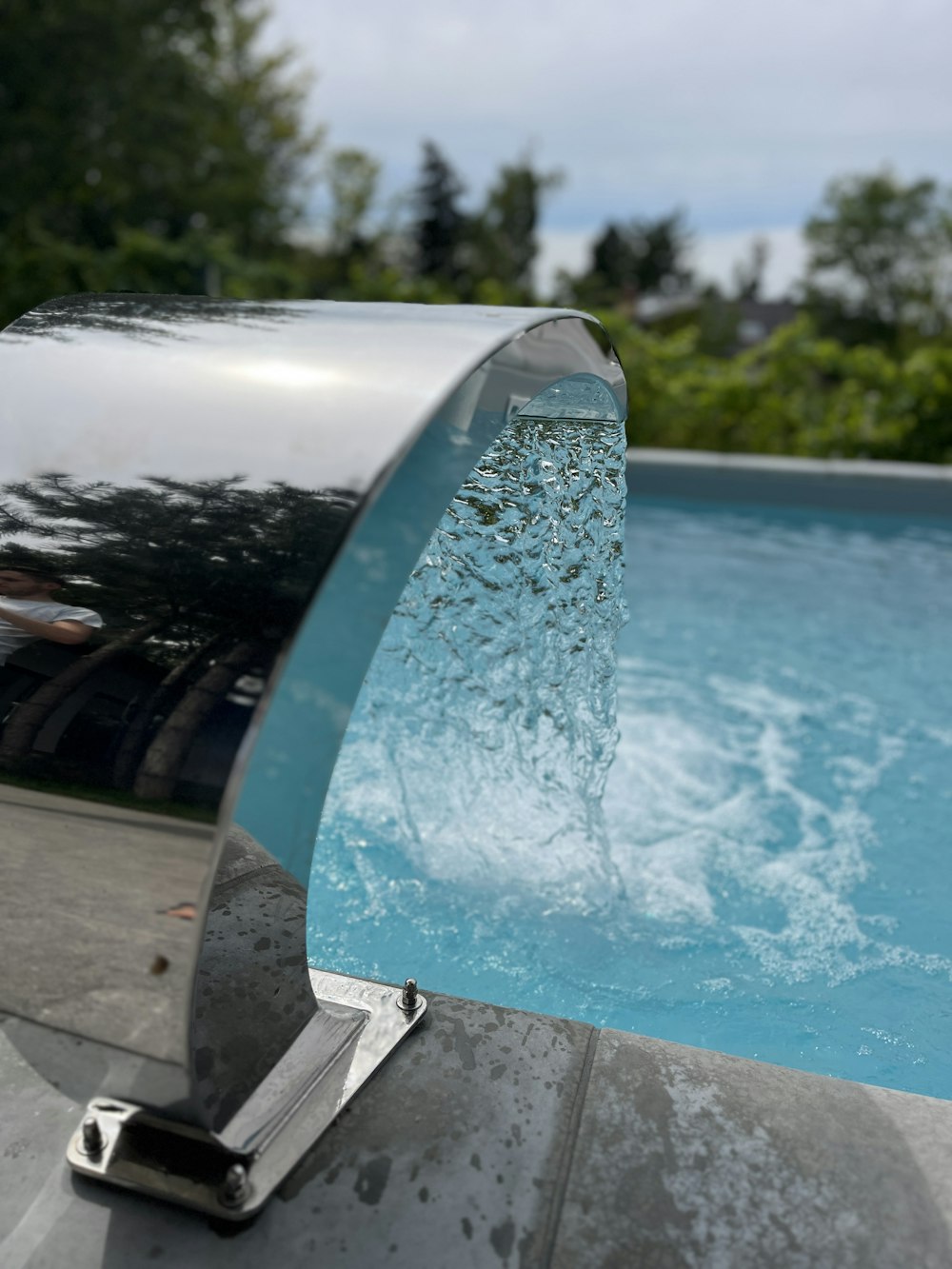 a pool with a water feature in the middle of it