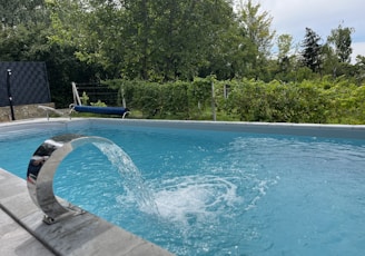 a blue swimming pool with a water spout