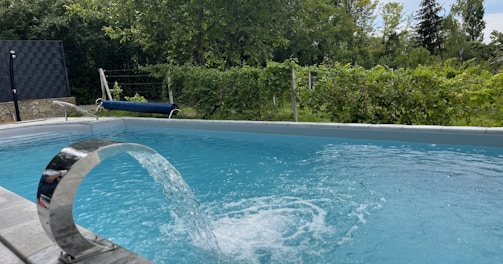 a blue swimming pool with a water spout