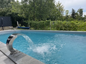 a blue swimming pool with a water spout