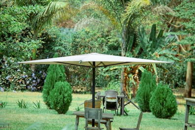 A sturdy patio umbrella with a weighted base casting shade over a garden table.