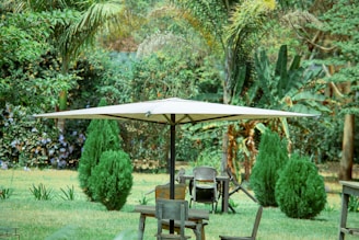 A sturdy patio umbrella with a weighted base casting shade over a garden table.