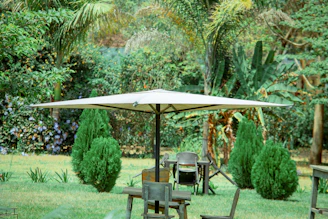 Sturdy patio umbrella base anchoring a vibrant umbrella beside a lush garden setting