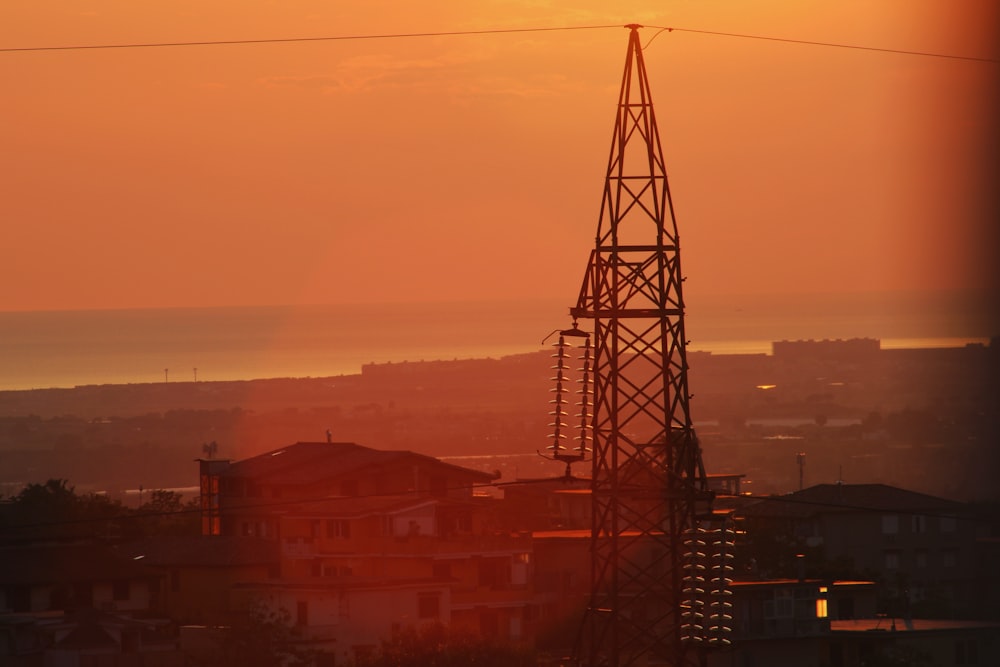 the sun is setting over a city with power lines