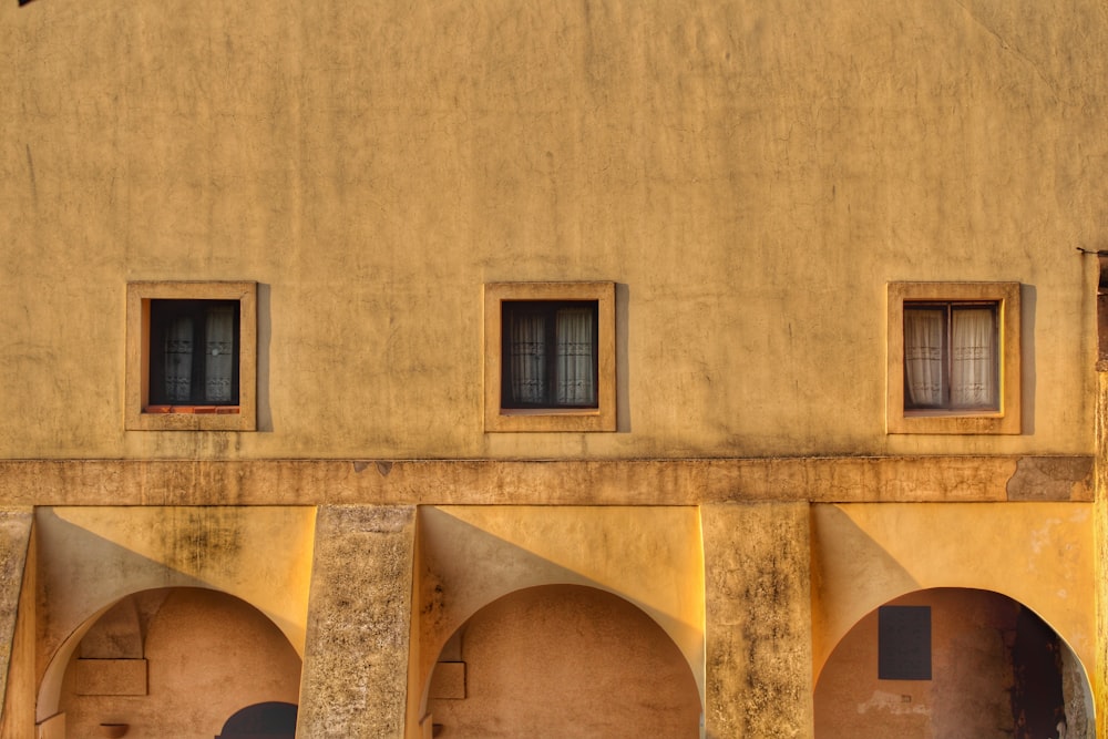 a building with three windows and a clock on the side of it