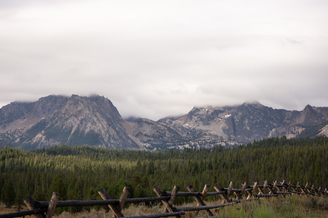 a wooden fence in front of a mountain range,