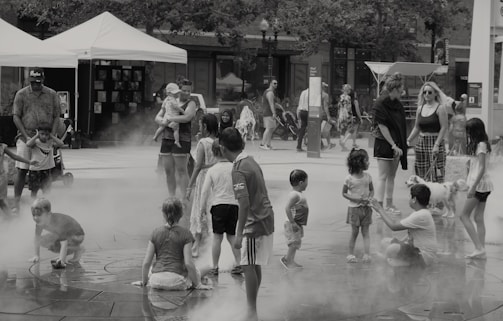 Families receiving hygiene kits during a sunny day in a neighborhood courtyard.