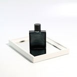 a bottle of perfume sitting on top of a mirror