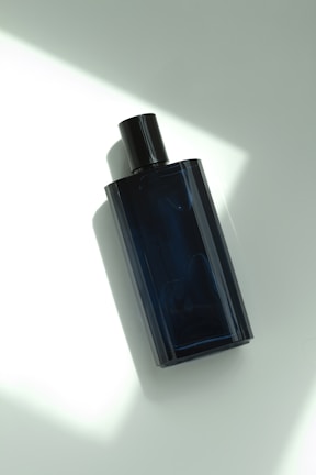 a bottle of cologne sitting on top of a white table