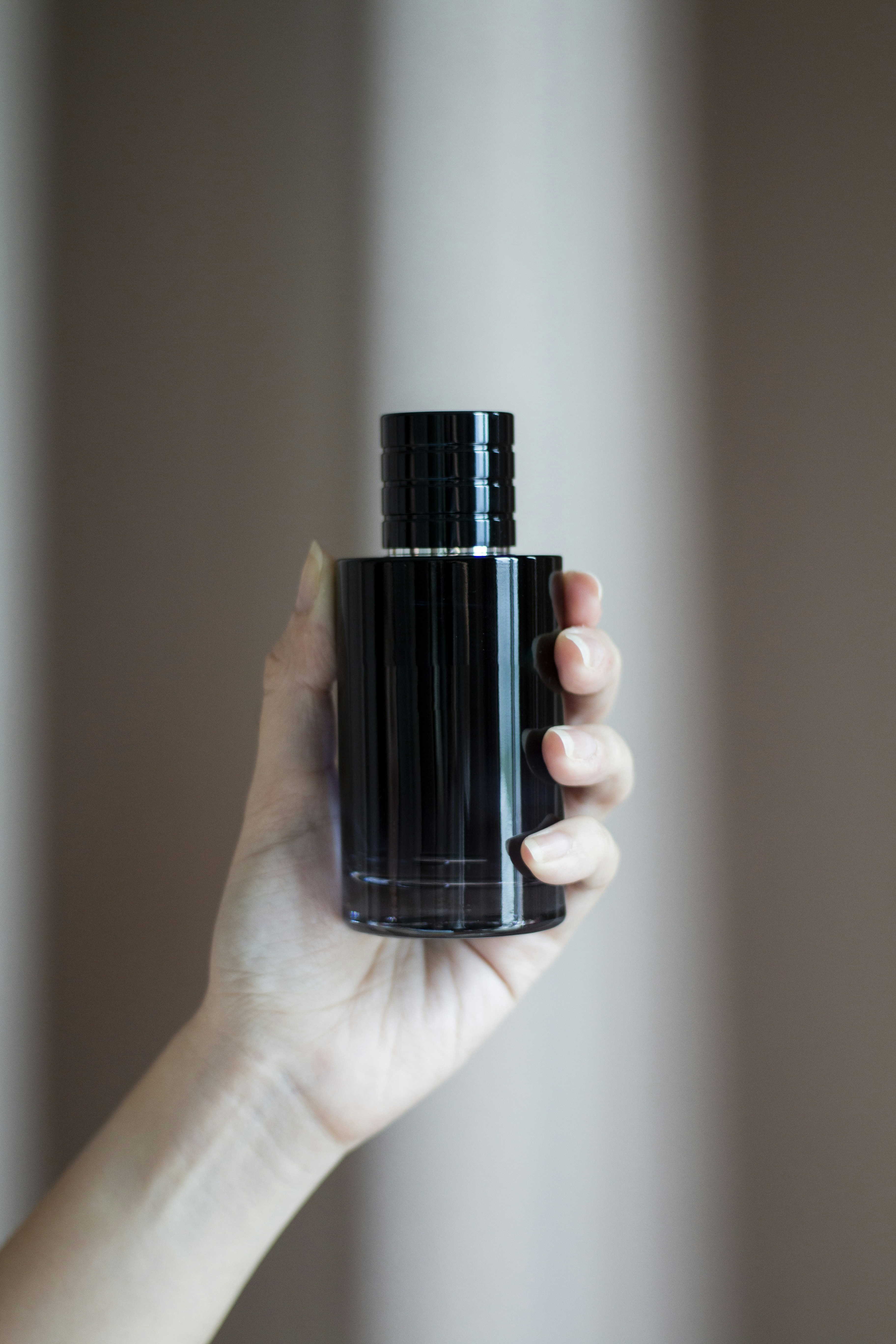 a person holding a black bottle in their hand