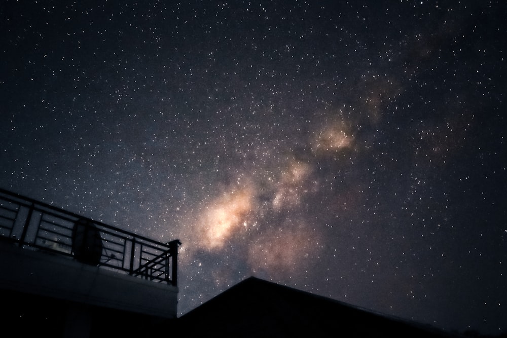 a person standing on a balcony looking at the stars