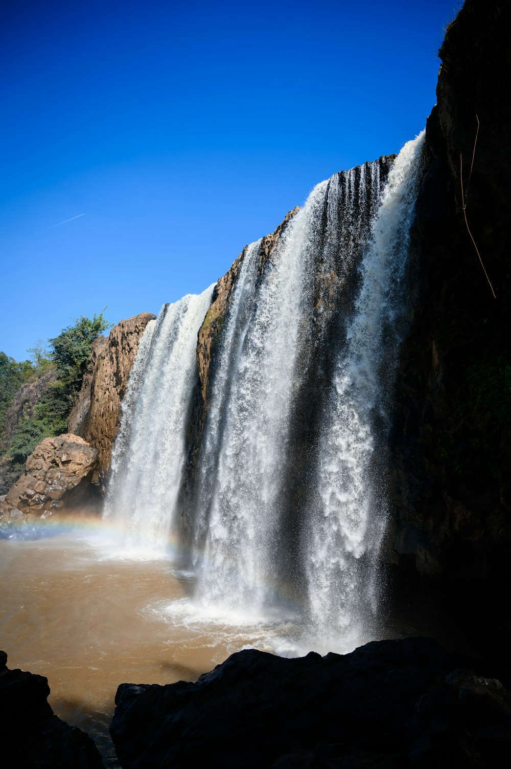 a large waterfall with a rainbow in the middle of it