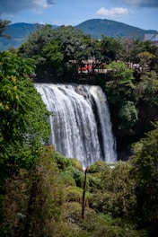 a large waterfall with a bridge over it