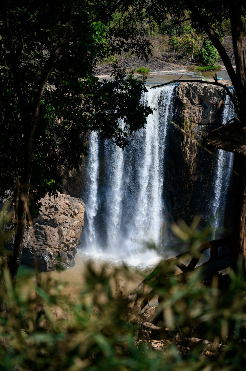 a view of a waterfall through some trees