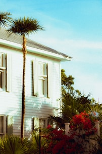 Exterior house being painted with fresh white paint on a sunny day.