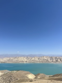 A serene landscape featuring mesas under a clear blue sky.