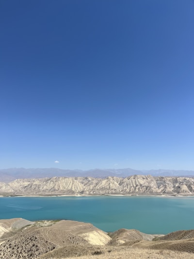 A serene landscape featuring mesas under a clear blue sky.