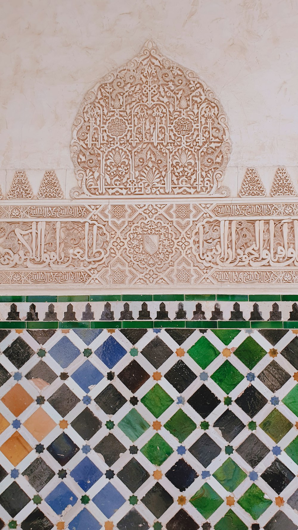 a close up of a tiled wall with a clock on it