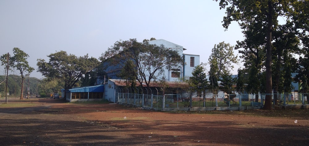 a large blue building sitting next to a forest