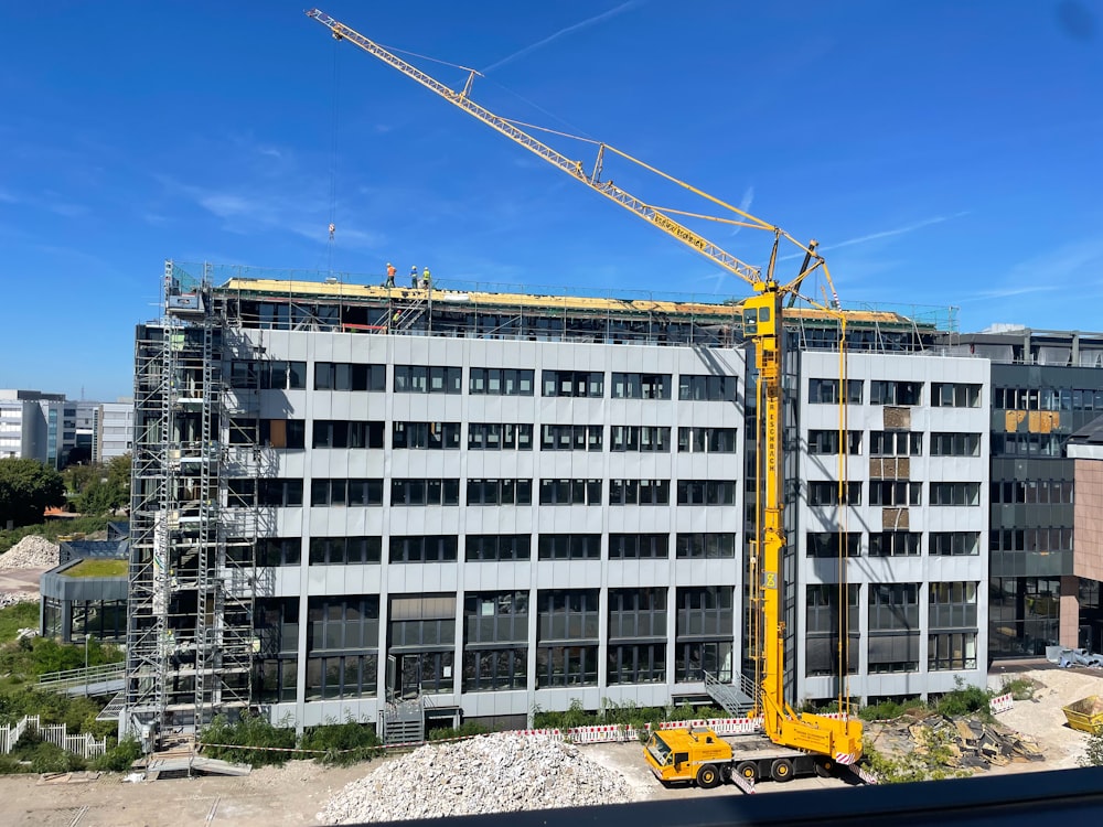 a crane is standing in front of a building under construction