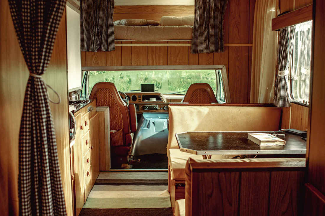 Interior of a camper set up with a desk and chairs