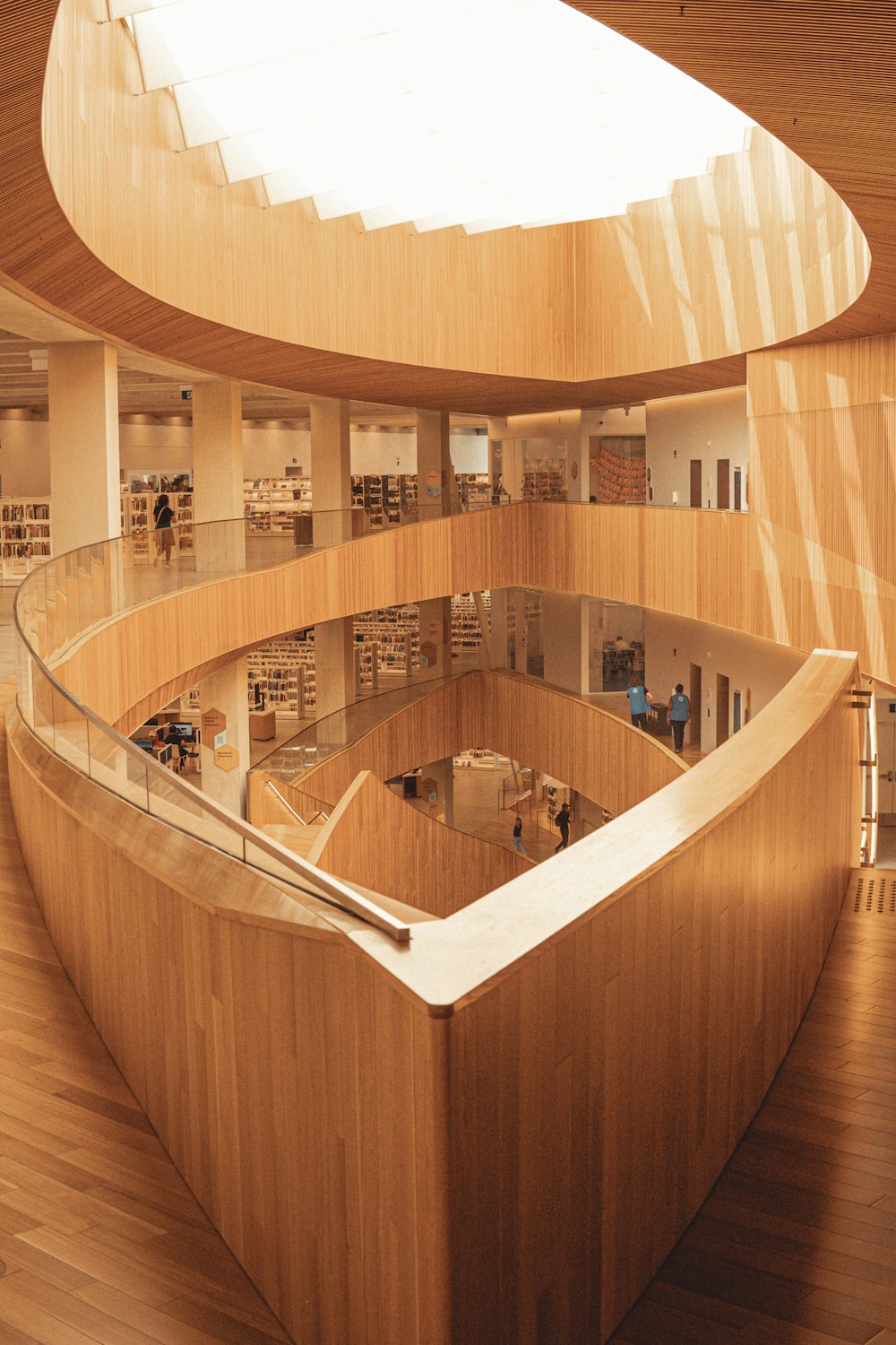 a curved wooden staircase in a library