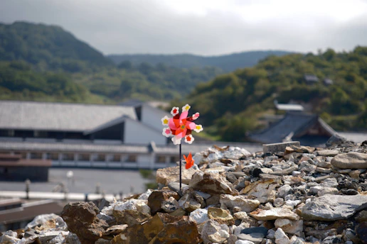 A peaceful view of the stone pinwheel sculpture surrounded by lush greenery in the park.