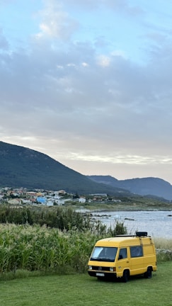 West Cork Movers team smiling beside the black van, set against a backdrop of lush green countryside.