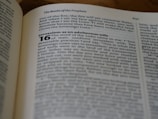 An open book lies on a flat surface. The visible text is from a religious scripture, specifically the section titled 'The Books of the Prophets.' The passage highlights a verse regarding Jerusalem, discussing themes of faithfulness and divine judgment.