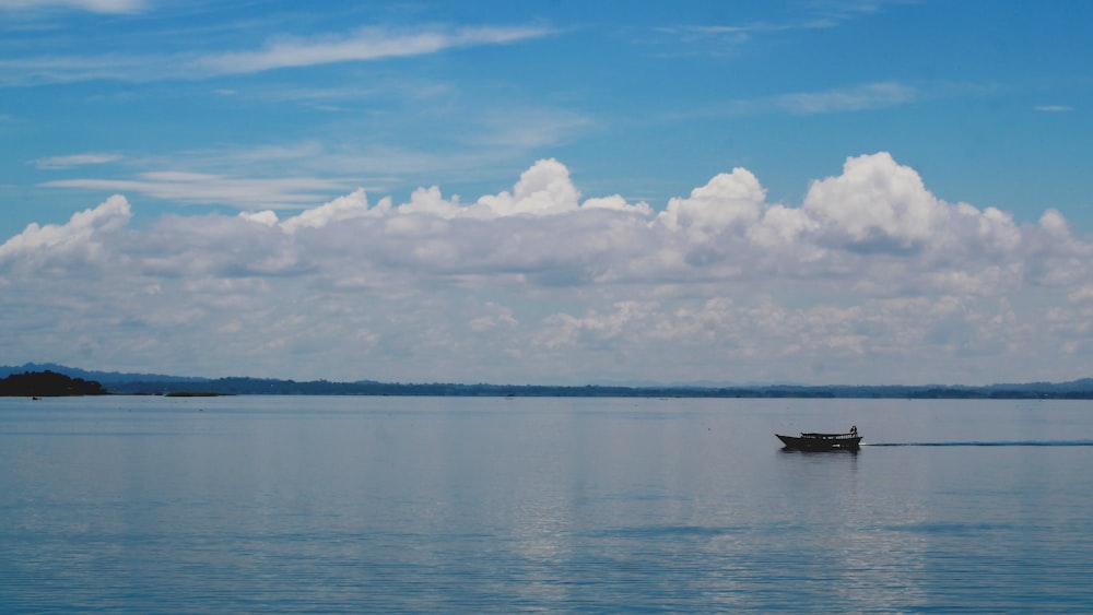 a small boat floating on top of a large body of water