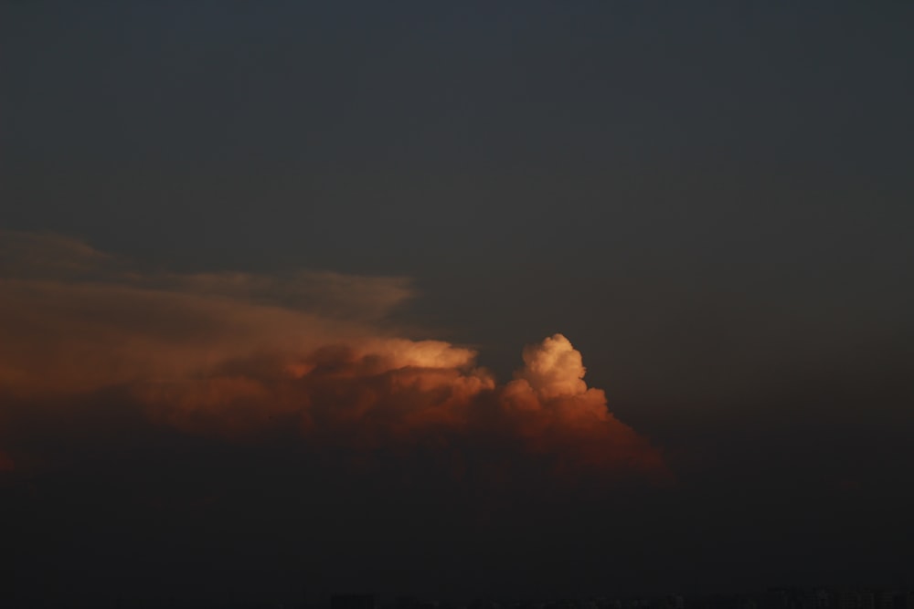 a plane flying in the sky at sunset