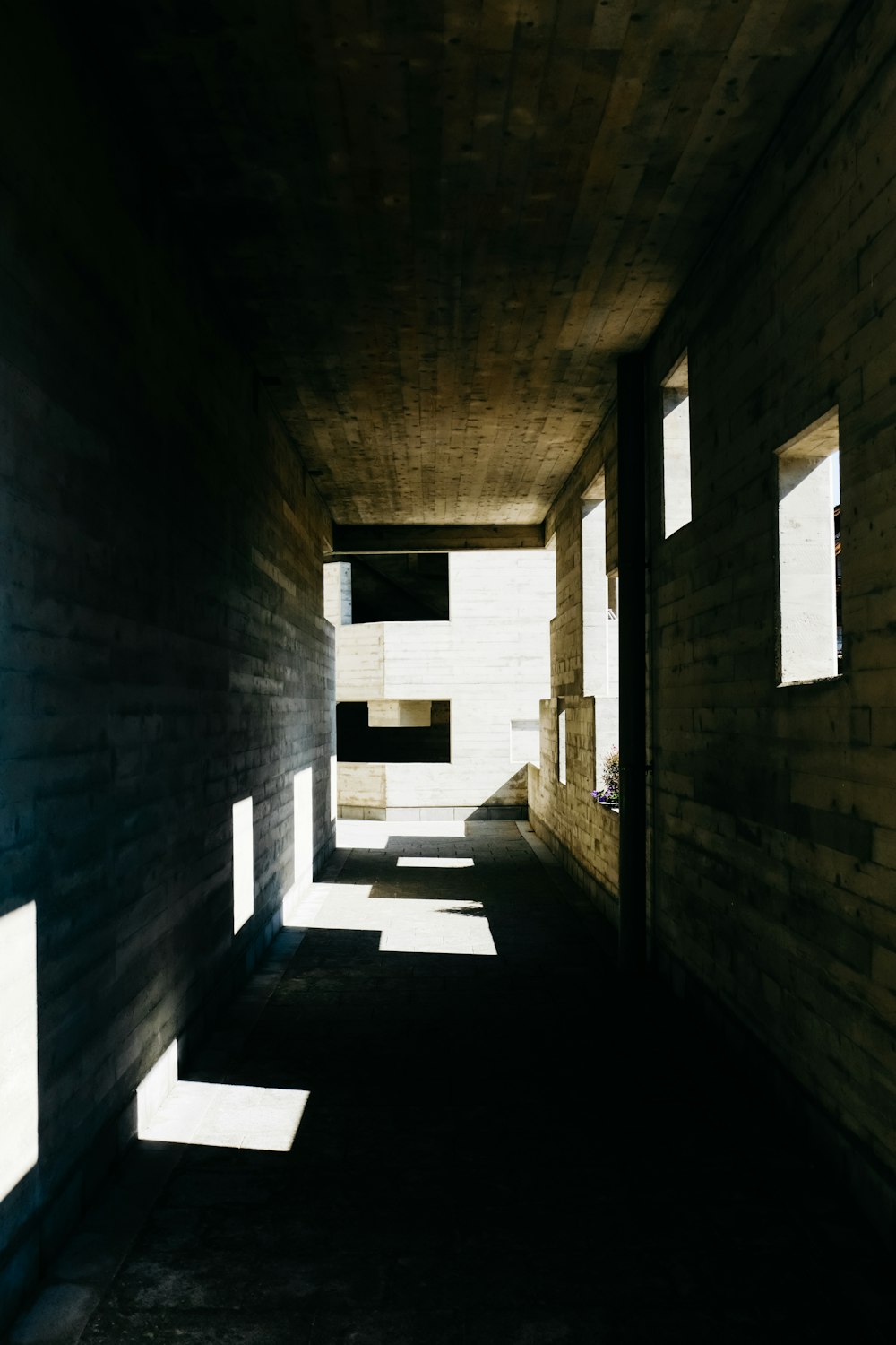 a long dark hallway with light coming through the windows