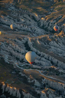A vibrant sunrise over Cappadocia's fairy chimneys with hot air balloons drifting gently in the sky.